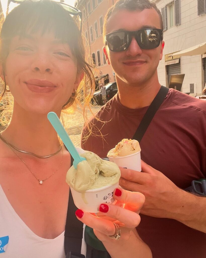 A man and a woman holding cups of gelato. 