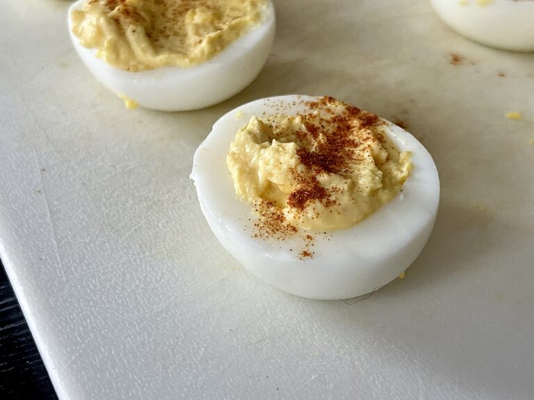deviled eggs on a white cutting board.