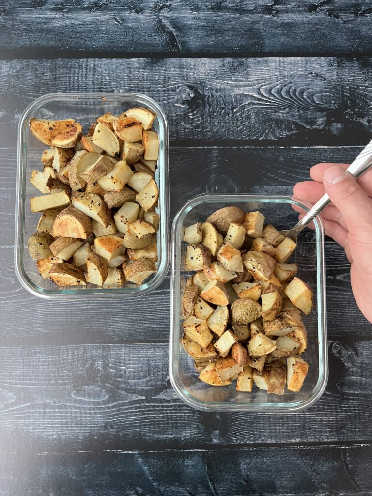 garlic roasted potatoes diced in glass meal prep containers.