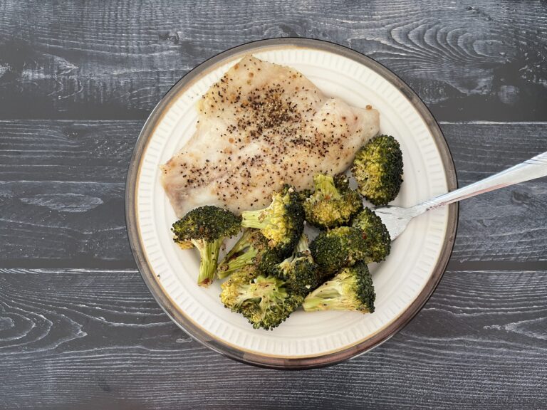 Lemon pepper tilapia served on a plate with roasted broccoli.