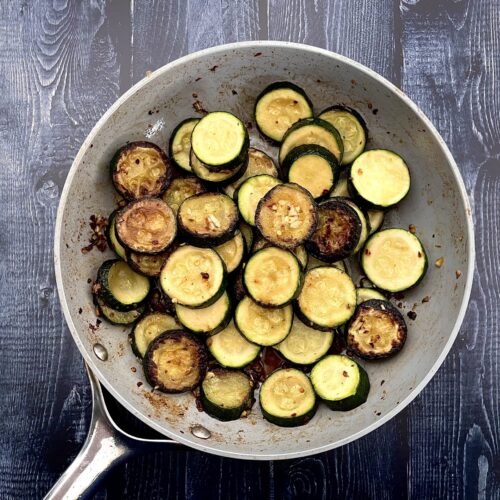 sauteed zucchini in a frying pan with garlic.