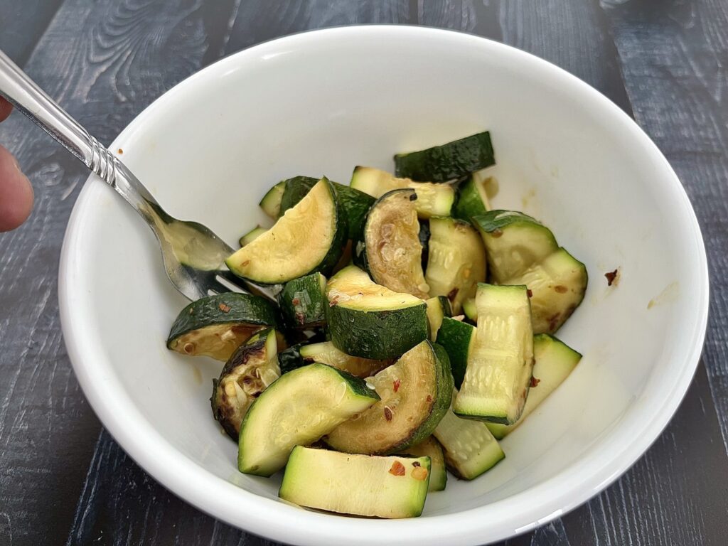 sauteed zucchini in a white bowl.