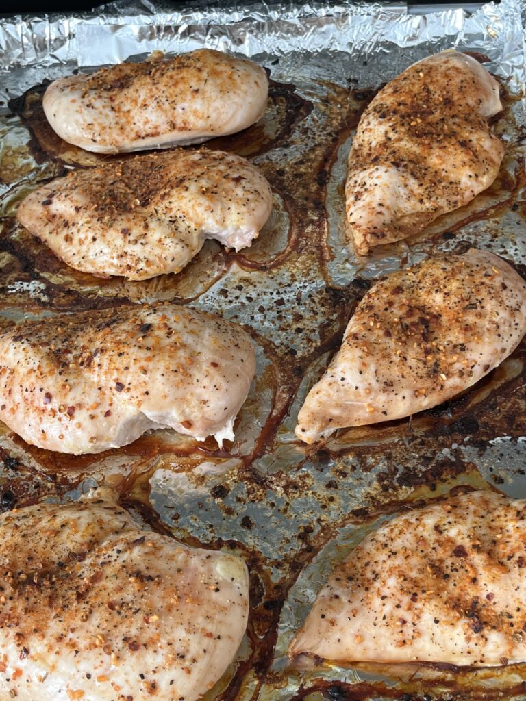 Baked chicken breasts on a baking sheet.