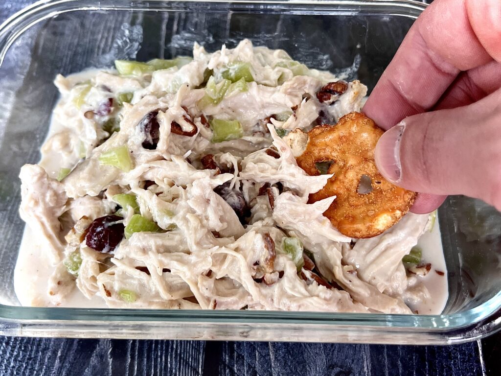 chicken salad in a glass container server with crackers.