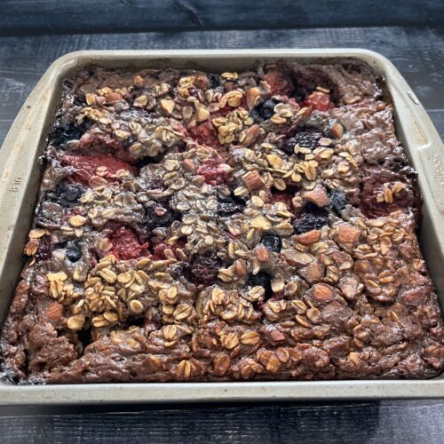 A baking dish with baked oatmeal with berries.