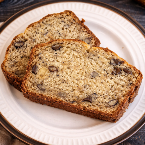 Two slices of homemade banana bread on a plate.
