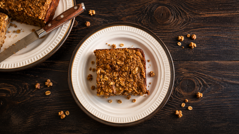 A square of banana baked oatmeal on a wooden table.